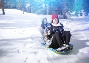 A pair of adorable girls having fun with a blue lightening tube