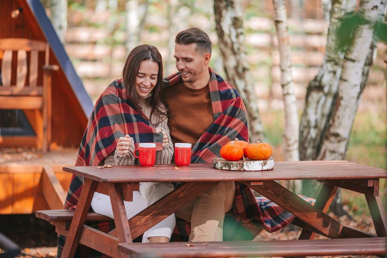 young-couple-with-coffe-on-yard-of-their-house-at-winter